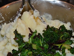 Kale and onion being mixed into the mashed potato - The Irish Place