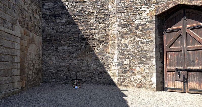 The Stonebreakers Yard showing the gate where the ambulance came to and the cross marking the spot where James Connolly was executed - The Irish Place