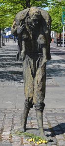 A child too weak to walk being carried (Famine Memorial Statues) - The Irish Place