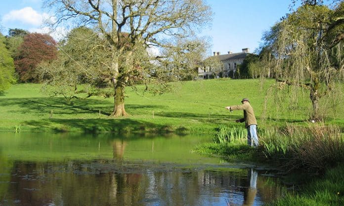 A Fly Fisherman casting his line on one of the lakes in the grounds of Ballyvolane House, Co. Cork - The Irish Place