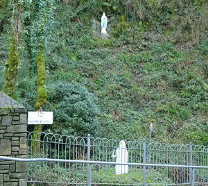 The Holy Well/Grotto near to Mount Melleray Abbey with a statue of Our Lady of Lourdes high on the cliff face and a statue of St Bernadette below near the stream - The Irish Place