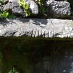 The Ogham Stone used as a lintel in the lower window in the Western Gable wall.