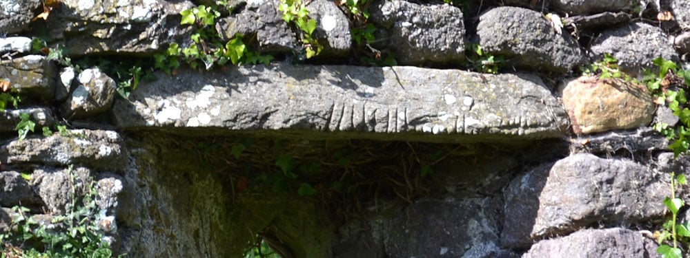 The Ogham Stone used as a lintel in the lower window in the Western Gable wall in Seskinan Church - The Irish Place